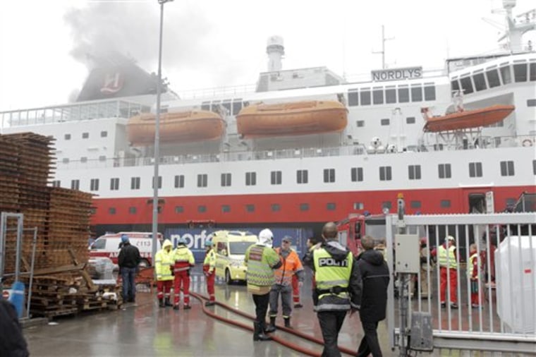 Smoke rises from the Norwegian cruise ship, MS Nordlys, one of the classic Hurtigruten ships alongside in Alesund in western Norway, Thursday Sept. 15, 2011 as firefighters and police attend. The Sunnmore police district says that 106 passengers were evacuated into lifeboats before the vessel managed to dock into the port of Alesund. The rest of the passengers and crew were being evacuated. Police said no one was killed but three people were taken to hospital. The fire broke out in the engine room at 9.20 a.m. (0720 GMT). (AP Photo/Scanpix)  NORWAY OUT